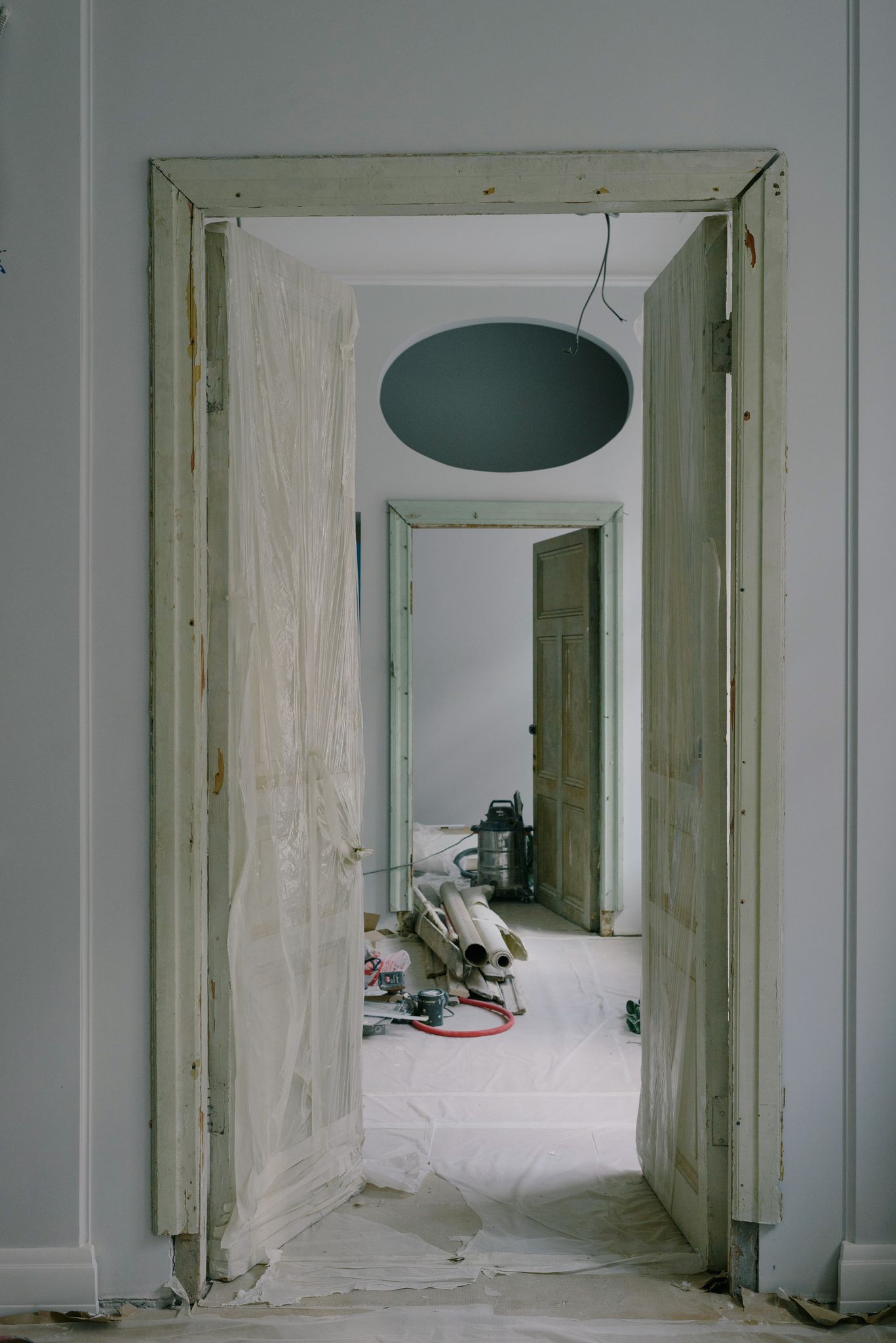 Contemporary house interior with open doors in cellophane and construction materials on floor in daytime